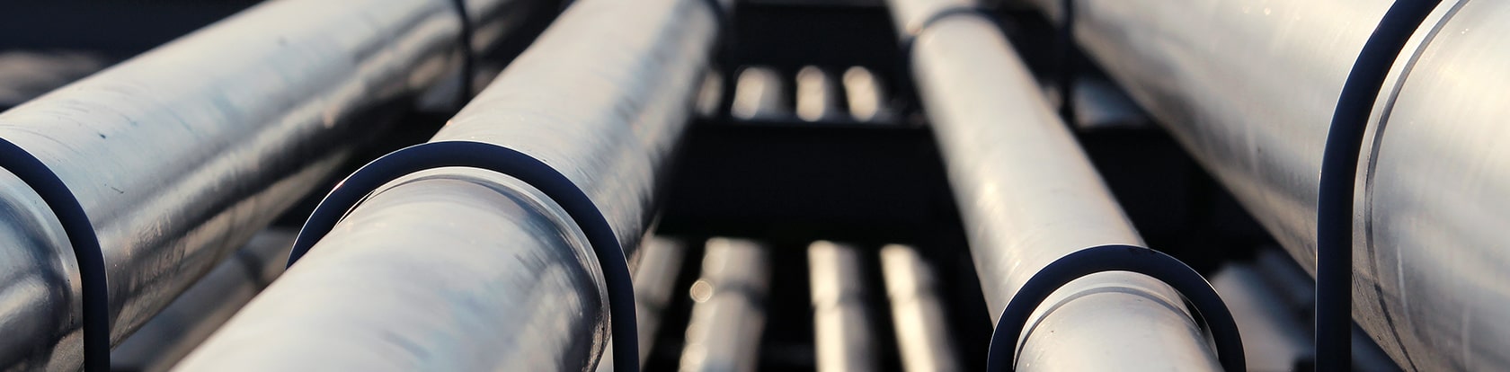 Mehrere Rohre symbolisieren die optimierten CI/CD-Pipelines, die an die VAIT-Anforderungen angepasst wurden, um eine höhere Stabilität und Transparenz im Reporting zu gewährleisten.