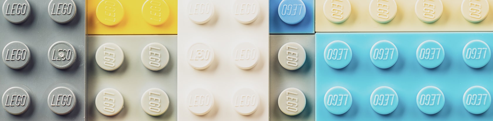 Aneinandergereihte Legobausteine symbolisieren das Baukastenprinzip für modulare Onlineabschlüsse und effiziente Antragsstrecken in der Versicherungsbranche.