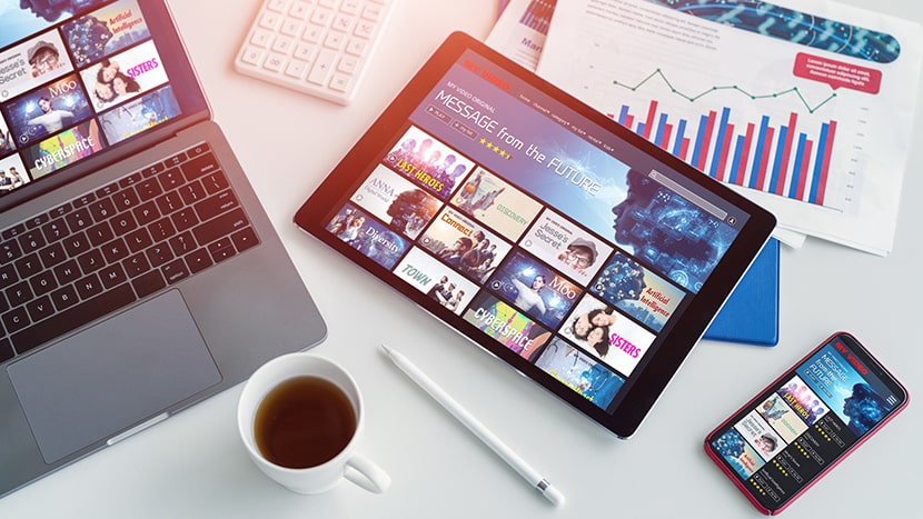 Anwendung synchronisiert über Laptop, Tablet und Mobiltelefon, symbolisiert die universelle Zugänglichkeit und nahtlose Integration in der App-Entwicklung für die Versicherungsbranche.
