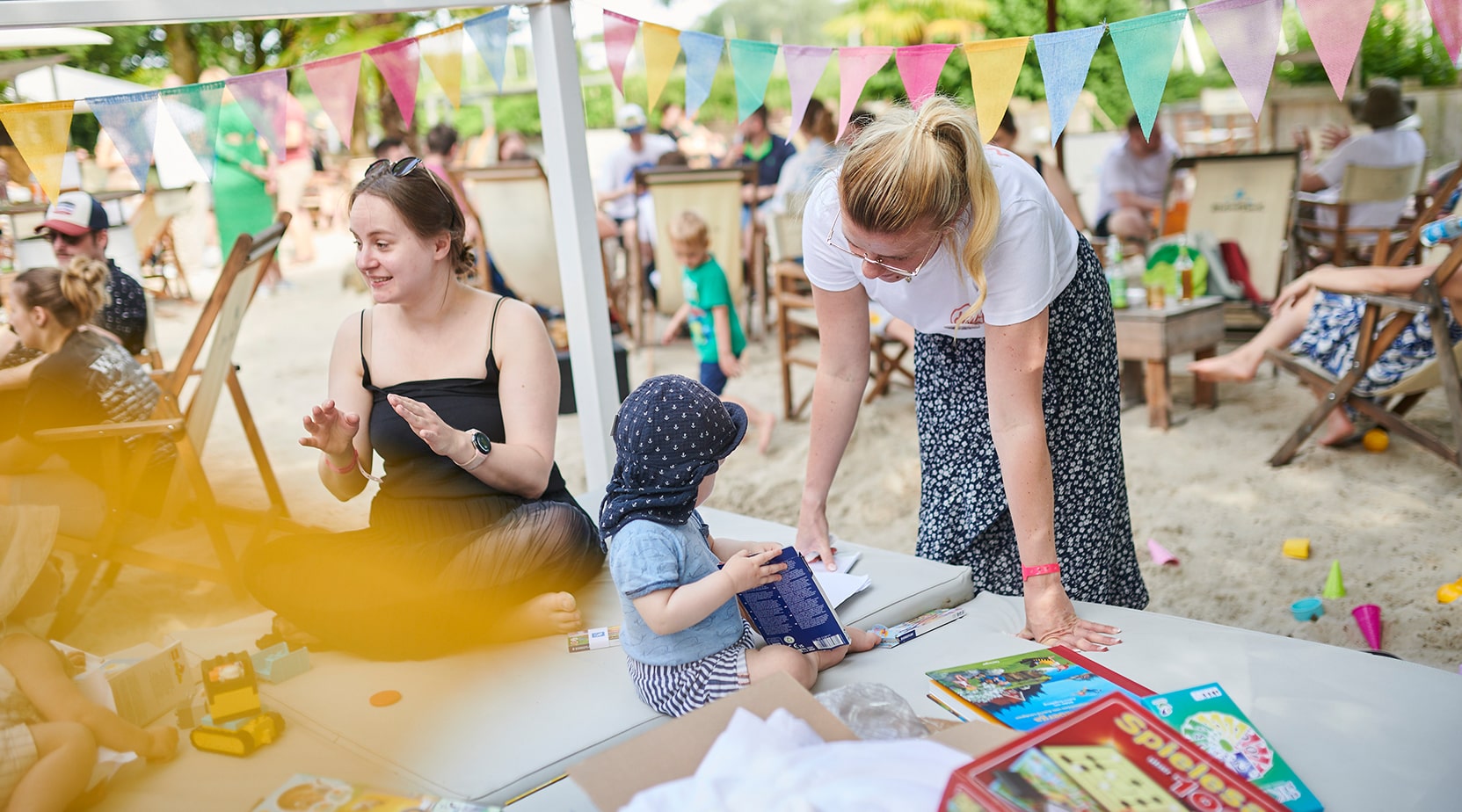 Eine Nanny betreut ein Kind auf dem Sommerfest der BROCKHAUS AG, was die familienfreundliche Personalpolitik des Unternehmens verdeutlicht.
