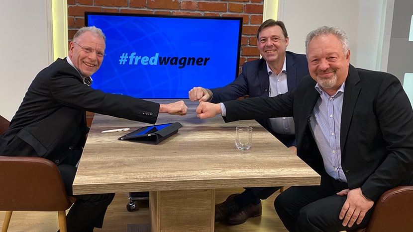 Fred Wagner, Dr. Wolfgang Breuer und Patric Fedlmeier sitzen zusammen an einem Tisch für eine neue Folge #fredwagner