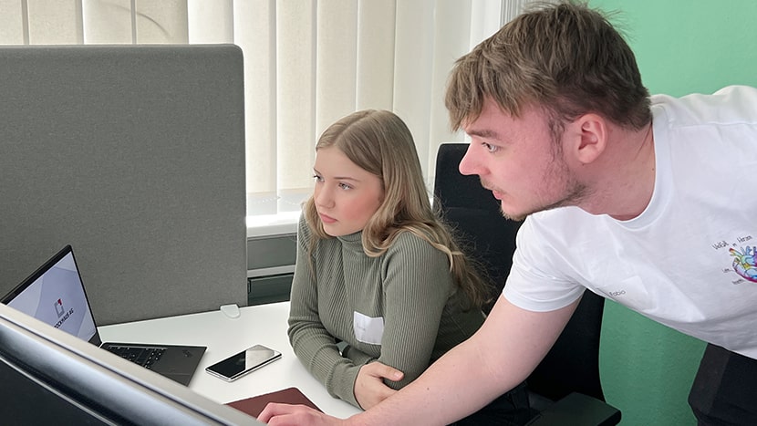 Mitarbeiter Fabio erklärt Teilnehmerin Hannah die Funktionsweise des Programms, damit sie ihre eigene App entwicklen kann