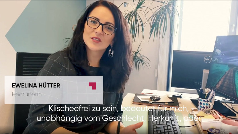 Das Bild zeigt einen Ausschnitt des Videos für die Initiative Klischeefrei und zeigt Mitarbeiterin Ewelina an ihrem Schreibtisch, wie sie die Frage Was bedeutet Klischeefrei für uns, beantwortet.