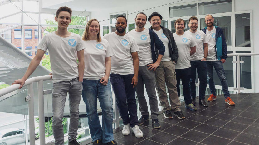 Die OpenValidation-Teammitglieder stehen in einer Reihe und lächeln in die Kamera