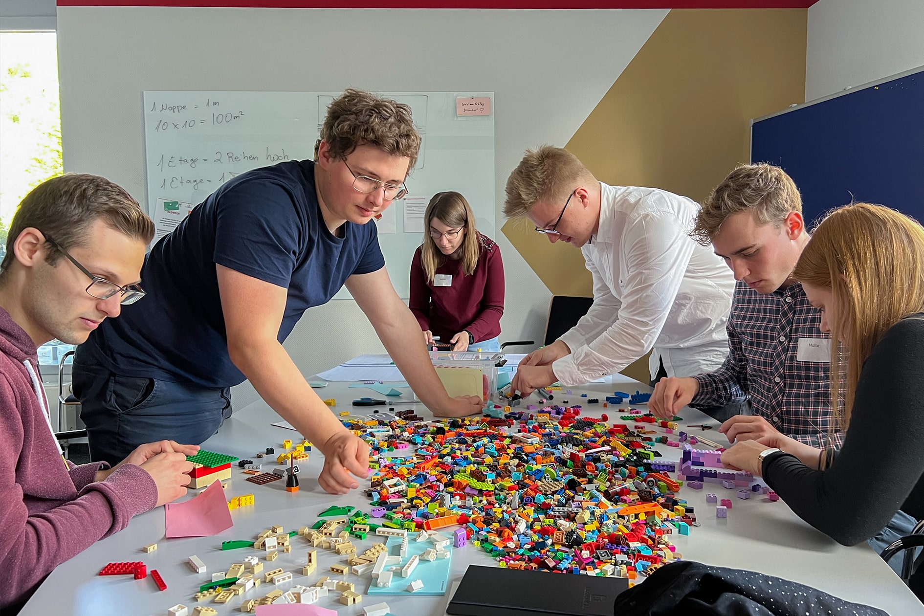Studierende vor einem Berg von Bausteinen