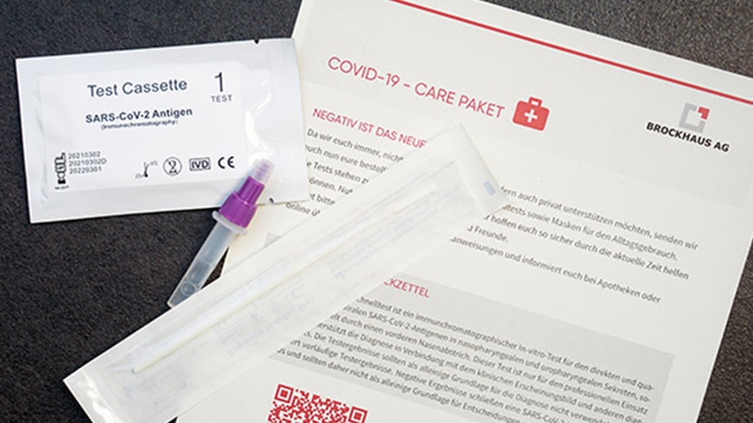 Inhalt des Covid Care Paketes der BROCKHAUS AG für die Mitarbeiter, darunter ein Brief und ein Testkit